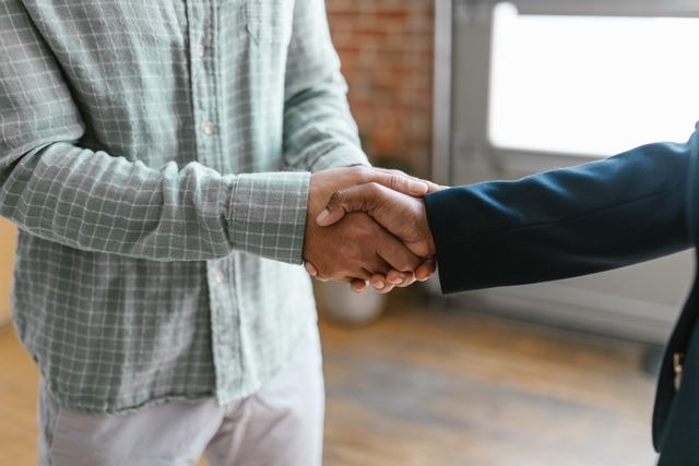 two people shaking hands indoors