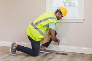 A person inspecting an air vent with a flashlight